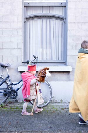 Kindje verkleed met mantel, mijter en stokpaardje