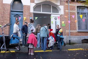 Kinderen verkleed samen met ouders aan de schoolpoort