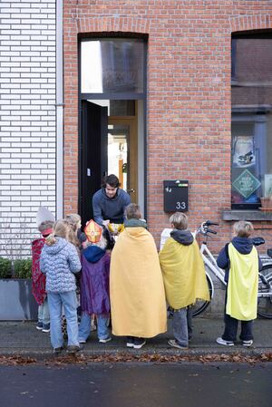 Zingende kinderen aan een geopende deur