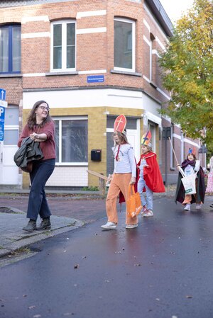 Kinderen verkleed met mijter, mantel en zwaard op stap