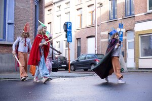 Kinderen verkleed met mijter, mantel en zwaard op stap