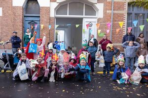 Kinderen verkleed poseren voor de schoolpoort