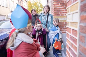 Drie kinderen verkleed met mijter en mantel wachten voor een deur