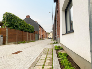 De vernieuwde, klimaatvriendelijkere Kerkhofstraat. De voegen tussen sommige tegels is groter zodat regenwater gemakkelijk de grond in kan sijpelen tijdens hevige regenbuien. 